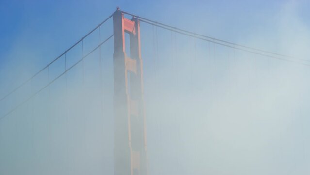 Golden Gate Bridge tower support is obscured by morning fog