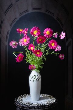 Still life with bouquet of red daisies on a black background