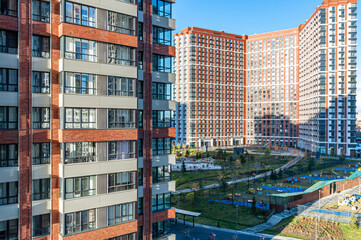 Bird's-eye view of a new residential area of the city of Moscow, high-rise buildings and a courtyard with playgrounds and carousels. View from above. Urban landscape.