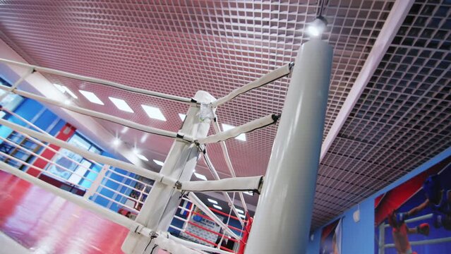 Corner of boxing ring with soft ropes in fighting gym zoom out. Arena for sportsmen training in modern sports center. Martial arts