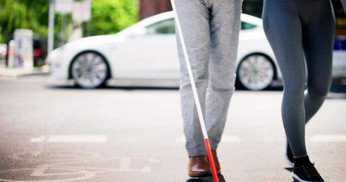 Young Woman Helping Blind Man With White Stick
