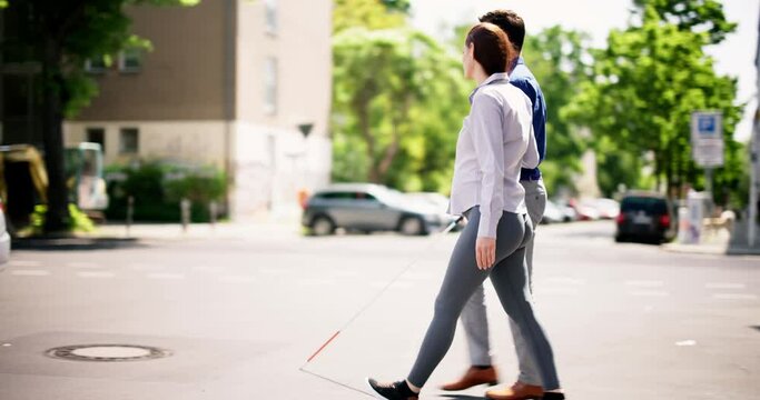 Young Woman Helping Blind Man With White Stick