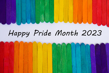 Colorful painted rainbow color on used ice cream sticks backgroud with text Happy Pride Month 2023....