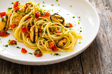 Spaghetti with mussels on wooden table
