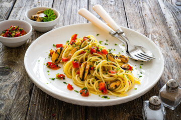 Spaghetti with mussels on wooden table
