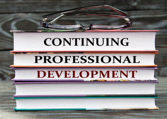 CONTINUING PROFESSIONAL DEVELOPMENT - words are written on books on a dark background