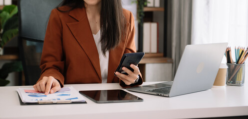 .Businesswoman hand using laptop, tablet and smartphone. Digital marketing media mobile app and discussing plan new start up project. Finance task.