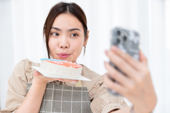 happy asian student chef selfie photo with smart phone for social with homemade delicious sweet cake bakery after cook in kitchen for post in social