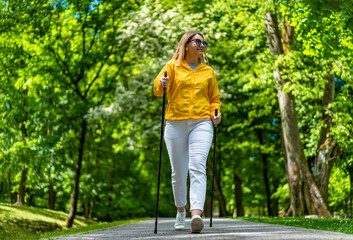Nordic walking - woman training in city park
