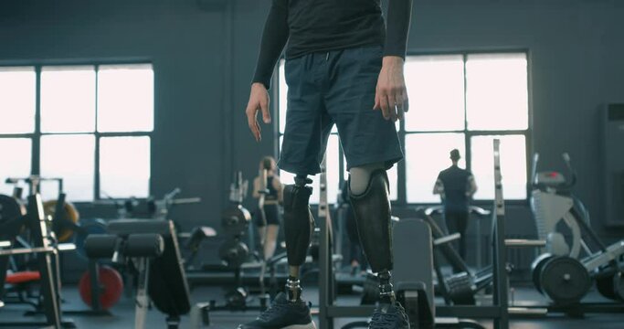 smiling happy handsome disabled man with bionic artifical legs standing on fitness box, Slow motion never give up, motivation new life strength success victory