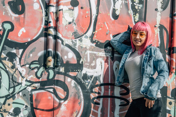 pink hair urban young woman leaning on wall