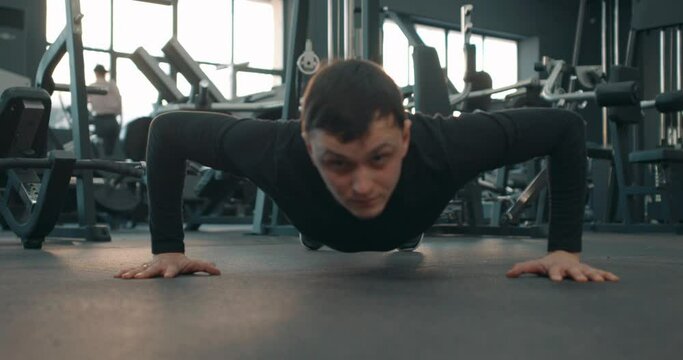 strong disabled sportsman with artificial leg limb training at gym and doing push-ups Slow motion Warming up or doing body weight exercises. motivation health and body care strength, lifestyle