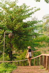 Naklejka premium Young woman step down by wooden stair in garden