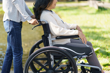 Fototapeta na wymiar Nursing home. Young caregiver helping senior woman in wheelchair.