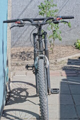 Fototapeta na wymiar one old black sports bike stands against a green wall on the street