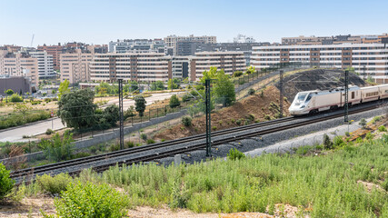 Ave high-speed train as it passes through the new neighborhoods of the city of Tres Cantos in Madrid.