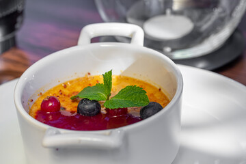 Dessert creme brulee or Catalan cream with mint leaves and berries