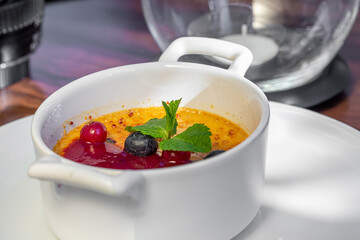 Dessert creme brulee or Catalan cream with mint leaves and berries