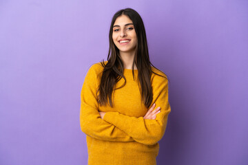 Young caucasian woman isolated on purple background keeping the arms crossed in frontal position