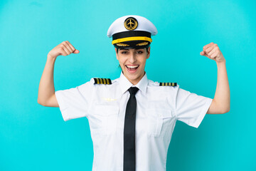 Airplane pilot caucasian woman isolated on blue background doing strong gesture