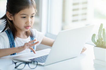 A girl is using a laptop computer for education and learning online.