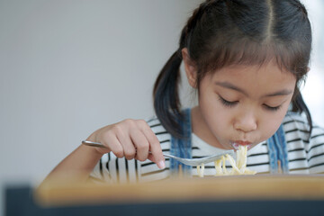 The girl is eating, girl eating spaghetti carbonara.