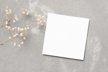 Blank square card mockup with dry flowers on grey background, greeting or invitation card mockup flat lay © nikavera