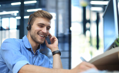 Smiling friendly handsome young male call centre operator