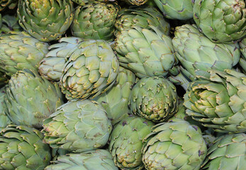 Obraz premium background of green large ripe artichokes for sale at market