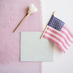 Obraz premium Top view with greeting card, white flower and American flag for event celebration
