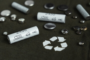 Flat lay with alkaline batteries on dark green background. Recycling chemical waste, environment...