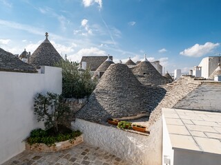 Fototapeta na wymiar Grey stone cone roofs of historical houses in Alberobello, Italy