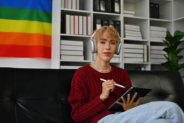 lifestyle of LGBT people concept with Young teenage boy wearing headphone and using digital tablet...
