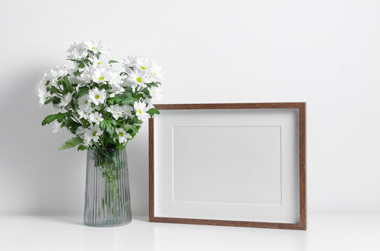 Wooden horizontal artwork frame mockup with white flowers bouquet
