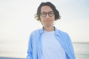 夕陽を背中に橋の上で微笑む男性