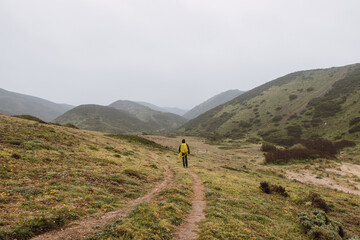 Obraz premium Wandering in heavy rain and wearing a raincoat along the Fisherman Trail in the southern part of Portugal during rainy weather heading to Cape St. Vicente. Rough landscape