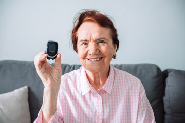 Senior diabetic woman with glucometer at home, diabetic disease awareness and control