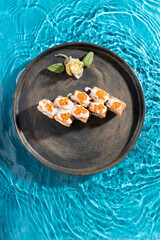 japanese cuisine sushi rolls on blue water background