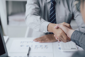 Two business people shake hands after a business deal is reached In the office area