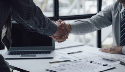 Two business people shake hands after a business deal is reached In the office area