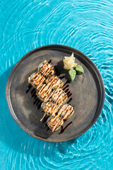 japanese cuisine sushi rolls on blue water background © victor198226
