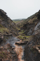 Walking through a gorge between two hills in rainy weather in the southwest of Portugal, Algarve region in March. Wandering along the Fisherman Trail