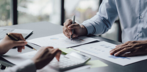 businessman or accountant hand working on calculator to calculate business data, accounting document and laptop computer at office, business concept