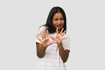 Young Indian woman cut out isolated on white background rejecting someone showing a gesture of...