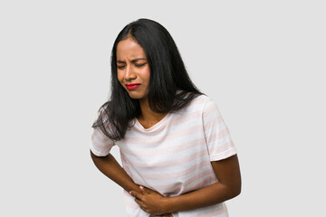 Young Indian woman cut out isolated on white background having a liver pain, stomach ache.