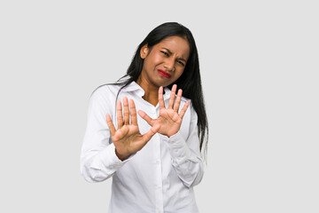 Young Indian woman cut out isolated on white background rejecting someone showing a gesture of...