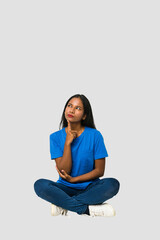 Young Indian woman sitting on the floor isolated on white background