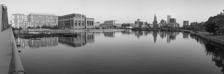 Panoramic Providence cityscape black and white retro style photo, with skyline and industrial buildings, tranquil water reflections, and the old Point Street Bridge over the river in Rhode Island 