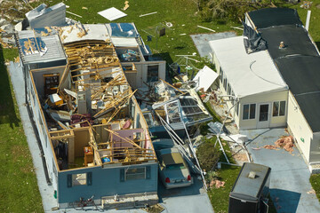 Severely damaged by hurricane Ian houses in Florida mobile home residential area. Consequences of...