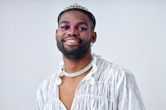 Half Body Portrait of happy 20-25 black bearded man with dark skin of american ethnicity in white sweet shirt and crown. Gay wear fashion style and poses over white studio Background isolated